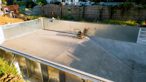 Das Bild zeigt einen leeren Pool im Garten, da sich dieser noch unter Konstruktion befindet. 