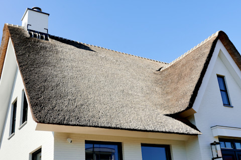 Das Bild zeigt ein Haus mit frisch gedeckten Reetdach