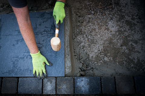 Ein Handwerker arbeitet an einer Bodenplatte