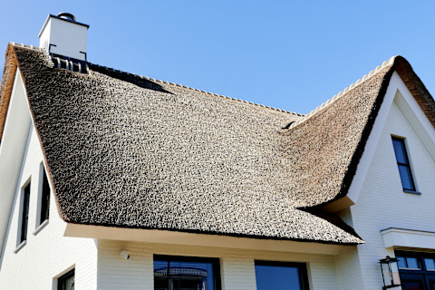 Das Bild zeigt ein Haus mit frisch gedeckten Reetdach
