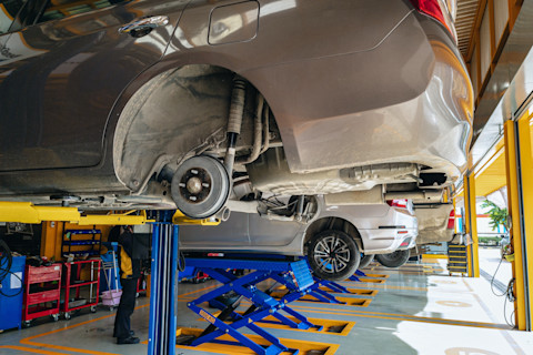 Das Bild zeigt mehrere Autos, die in einer KFZ-Werkstatt repariert werden.